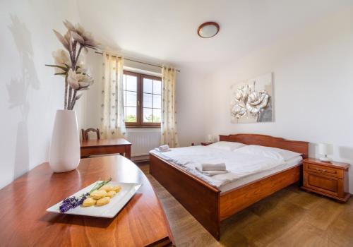 a bedroom with a bed and a table with a tray of fruit at Penzion Mušlov in Mikulov