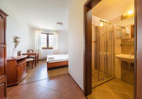 a bathroom with a bed and a shower and a sink at Penzion Mušlov in Mikulov