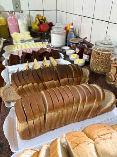 a table with several breads and other foods on it at Pousada Dom Luiz in Ouro Preto