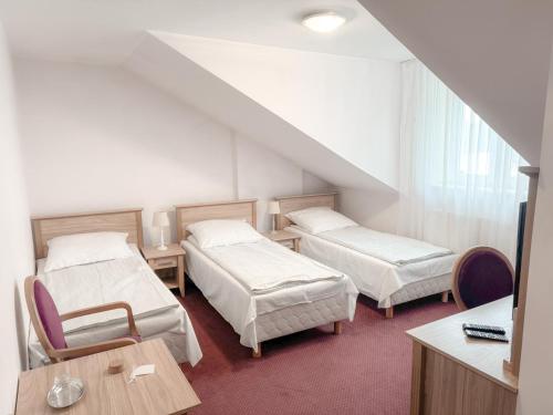 a hospital room with two beds and a table at Złote Runo - Kameralny hotelik & Restauracja in Karolina