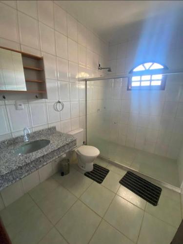 a bathroom with a toilet and a sink and a shower at Praia do fort in Camacari