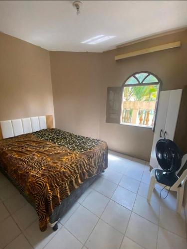 a bedroom with a zebra print bed and a window at Praia do fort in Camacari