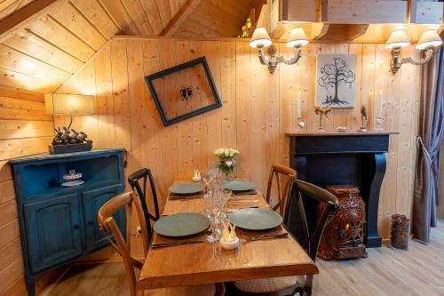 a dining room with a wooden table and a fireplace at Lodge Mon Petit Lapin in Montgon