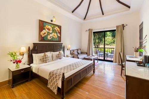 a bedroom with a bed and a living room at Anandam - A Luxury Resort in Udaipur in Udaipur