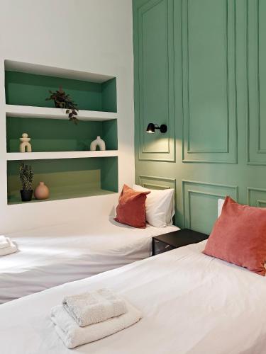 two beds in a room with green walls at Cosy room 9 in Tal-Pietà