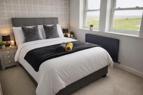 a bedroom with a bed with two pairs of shoes on it at Beautiful Beach Front Cottage in Allonby