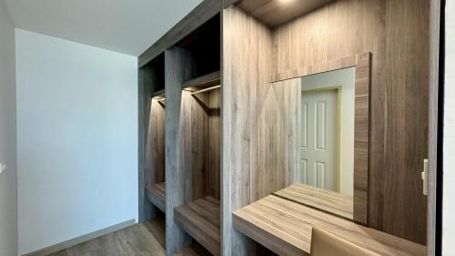 a dressing room with wooden walls and a mirror at Baan Suan Khun Ta and Golf Resort in Ubon Ratchathani