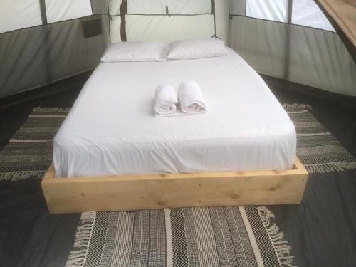 a bed in a tent with two towels on it at Barreira beachfront Tents 9 in Verga Kalamata