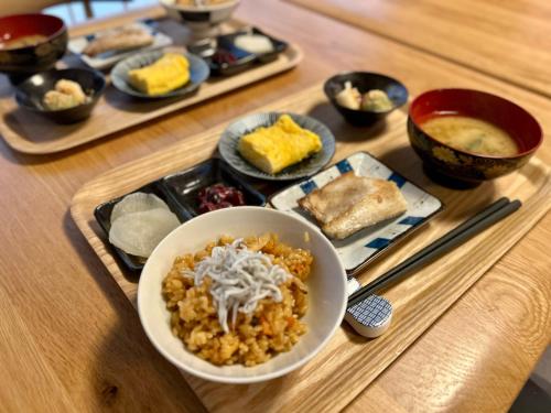 a table with a bowl of food and plates of food at Japanese Modern Inn Kamakura Rakuan Hanare---3min walk from Hase Station in Kamakura