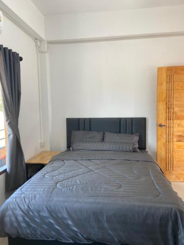 a bedroom with a large bed with a blue blanket at TN House in Pai