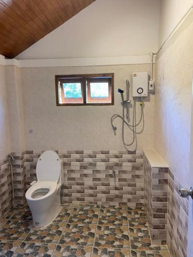 a bathroom with a toilet and a shower at TN House in Pai