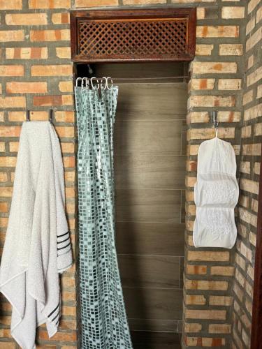 a bathroom with a shower and towels on a wall at Incanto in Niterói