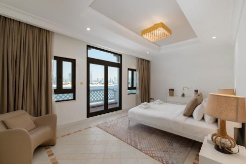a bedroom with a bed and a couch and windows at Palm Jumeirah - Property Advisers in Dubai