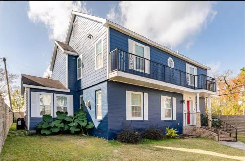 a blue and white house with a balcony at Lucky House 2 Tranquility in the Middle of Houston in Houston