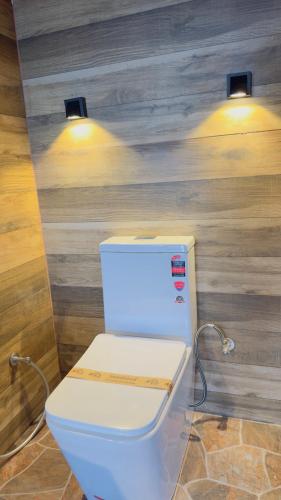 a bathroom with a toilet with two lights above it at Ayubowan, Ella in Ella