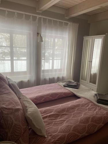 a bedroom with two beds and two windows at FeWo Naturgeflüster - Mecklenburger Outback - Garten & Kamin - Private Sauna in Zölkow