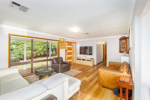 a living room with a couch and a table at Serene Farmhouse with Lake Views in Burrawang
