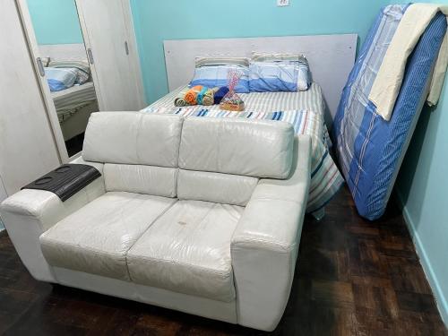 a white couch and a bed in a room at Lindo nascer do Sol II in Recife