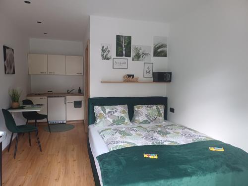 a bedroom with a bed and a table and a kitchen at Haus M&M in Brixen im Thale