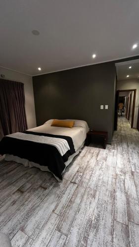 a bedroom with a large bed and a wooden floor at Casa Azahares in Yerba Buena