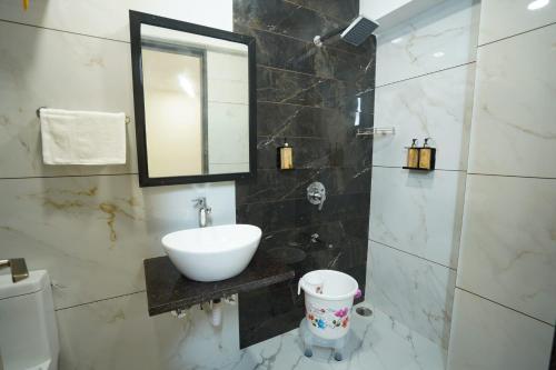 a bathroom with a sink and a mirror at Hotel Anugya in Indore