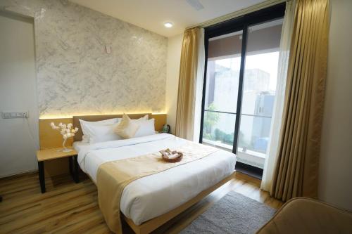 a bedroom with a bed and a large window at Hotel Anugya in Indore