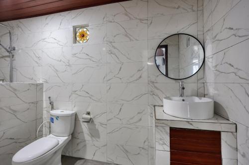 a bathroom with a toilet and a sink and a mirror at Road Beach Cottages in Nusa Penida