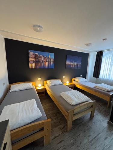 a room with two beds and two monitors on the wall at Pension Zwei A in Leverkusen