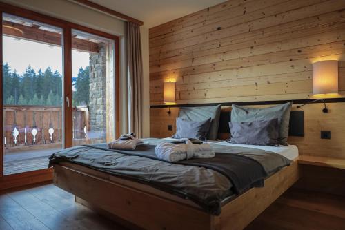 a bedroom with a large bed with a large window at PRIVÀ Alpine Lodge in Lenzerheide