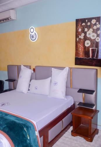 a bed with white pillows in a room at HOTEL DE LA VALLEE NEW in Yaoundé