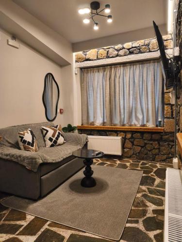 a living room with a couch and a window at Φεγγαρόπετρα-Ημισέληνος in Kalívia