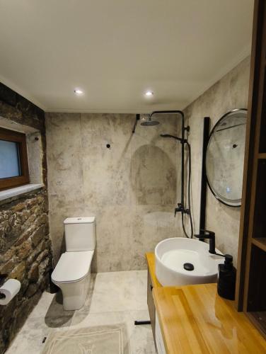 a bathroom with a toilet and a sink at Φεγγαρόπετρα-Ημισέληνος in Kalívia
