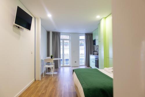 a hotel room with a bed and a table with a television at Stay In Vila Real Apartments in Vila Real