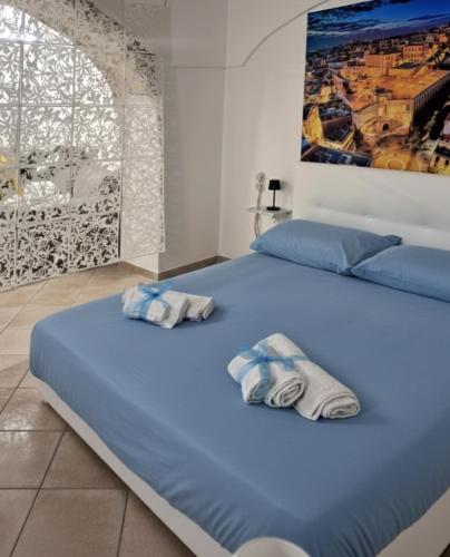a large blue bed with towels on top of it at Sa domu pitticca Cavour in Cagliari