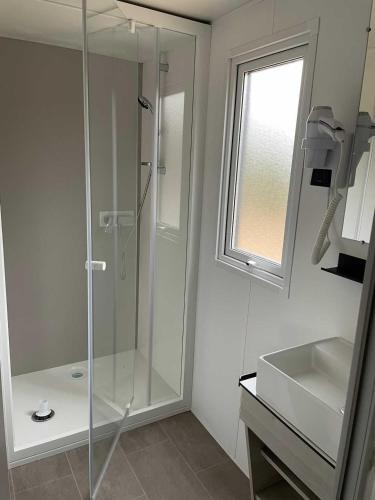 a bathroom with a glass shower and a sink at Bungalow le Sartène in Lumio