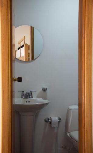 a bathroom with a sink and a mirror and a toilet at Villa Celia Casa Campo in Pueblo Bello