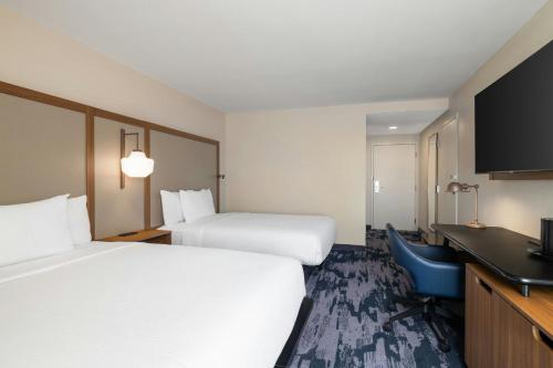 a hotel room with two beds and a desk at Fairfield by Marriott Inn & Suites Clinton in Clinton