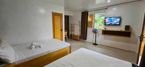 a bedroom with a bed and a flat screen tv at Vhora Inn Sibuyan in Magdiwang