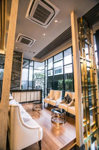 a lobby with couches and chairs and windows at Arte Hotel - SHA Extra Plus in Bangkok