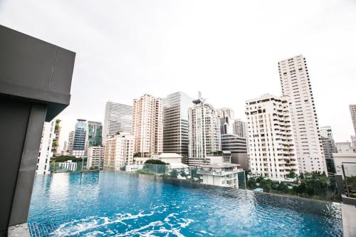 a large swimming pool in the middle of a city at Arte Hotel - SHA Extra Plus in Bangkok