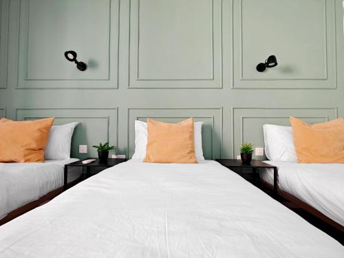two beds with orange pillows in a room at Cosy room 5 in Tal-Pietà
