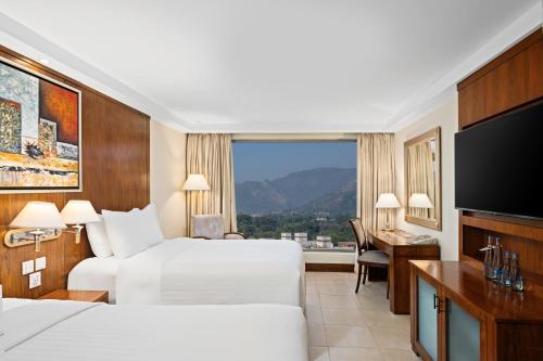 a hotel room with two beds and a flat screen tv at Islamabad Marriott Hotel in Islamabad