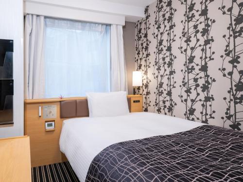 a hotel room with a bed and a window at APA Hotel Tokyo Itabashi Ekimae in Tokyo
