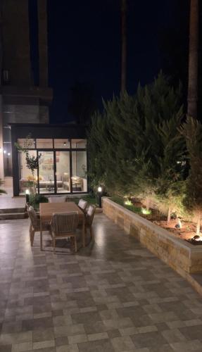 een terras met een tafel en stoelen 's avonds bij مطر in Amman