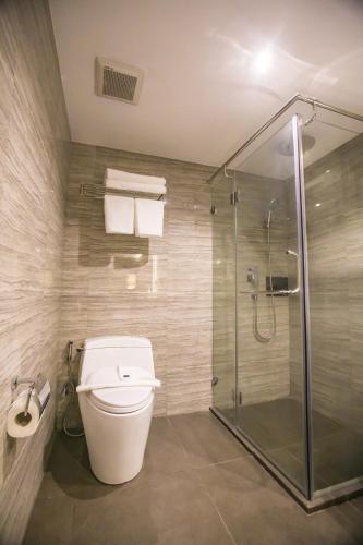 a bathroom with a toilet and a glass shower at Arte Hotel - SHA Extra Plus in Bangkok