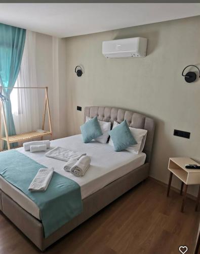 a bedroom with a large bed with blue pillows at Sığacıksenkonukevi in Siğacık