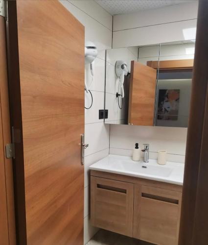 a bathroom with a sink and a wooden door at Sığacıksenkonukevi in Siğacık
