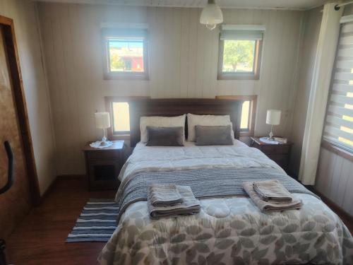 a bedroom with a large bed with two towels on it at Casa Isidora in Toltén