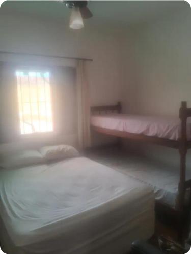 a bedroom with two bunk beds and a window at Quartos para locação in Mongaguá