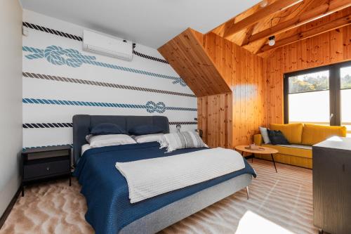 a bedroom with a blue bed and a couch at Wiatr od morza Jantar - BursztynoveLove in Jantar
